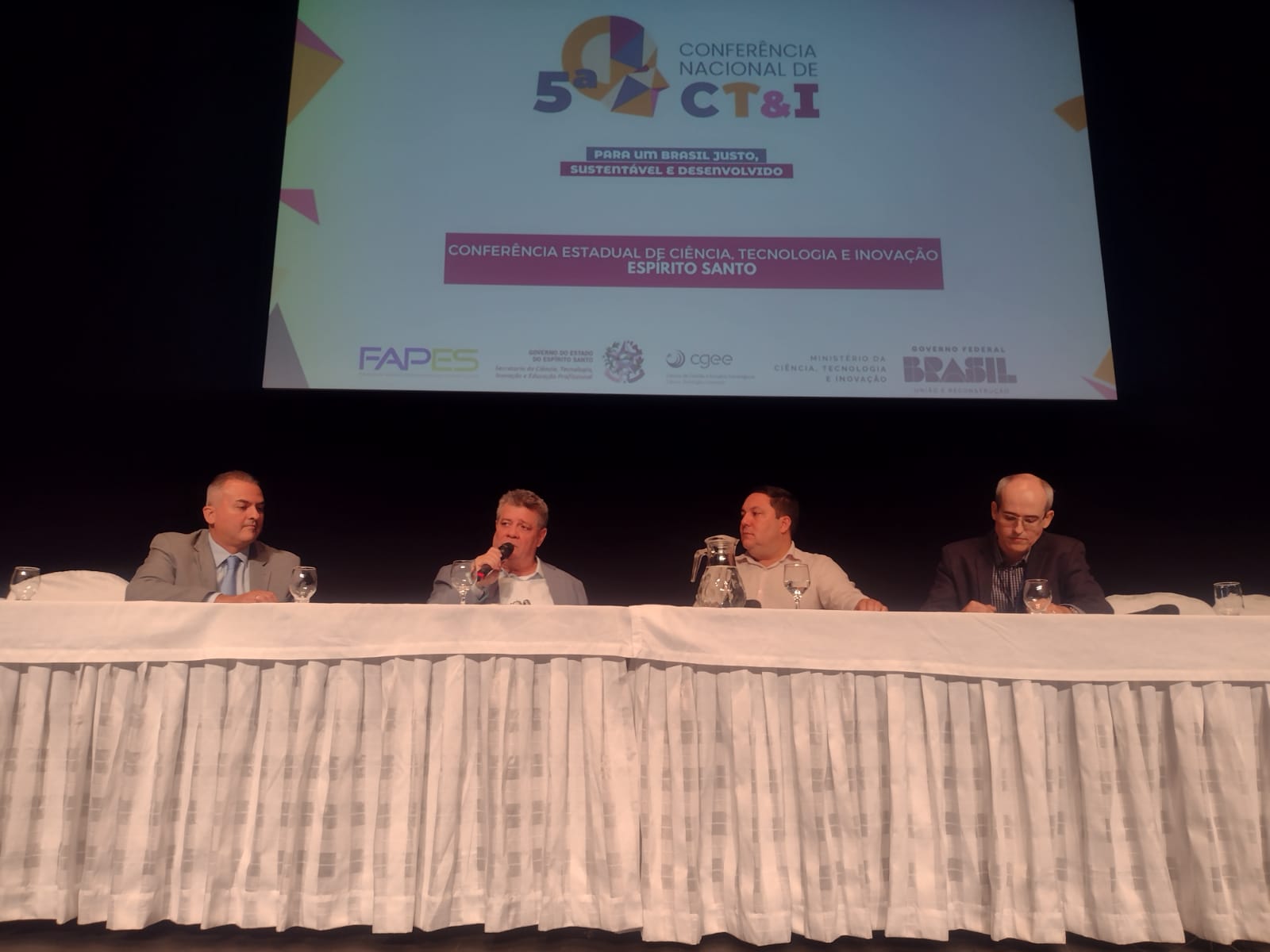 Mesa de debate com quatro participantes, entre eles o reitor da Ufes e o secretário de Ciência, Tecnologia e Inovação do governo do Estado