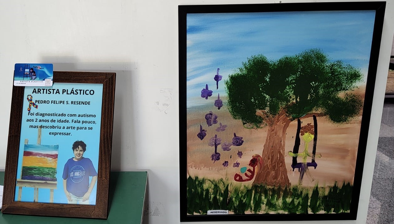 Quadro de Pedro Felipe e, do lado esquerdo, um porta retrato com a foto e uma breve apresentação do artista.