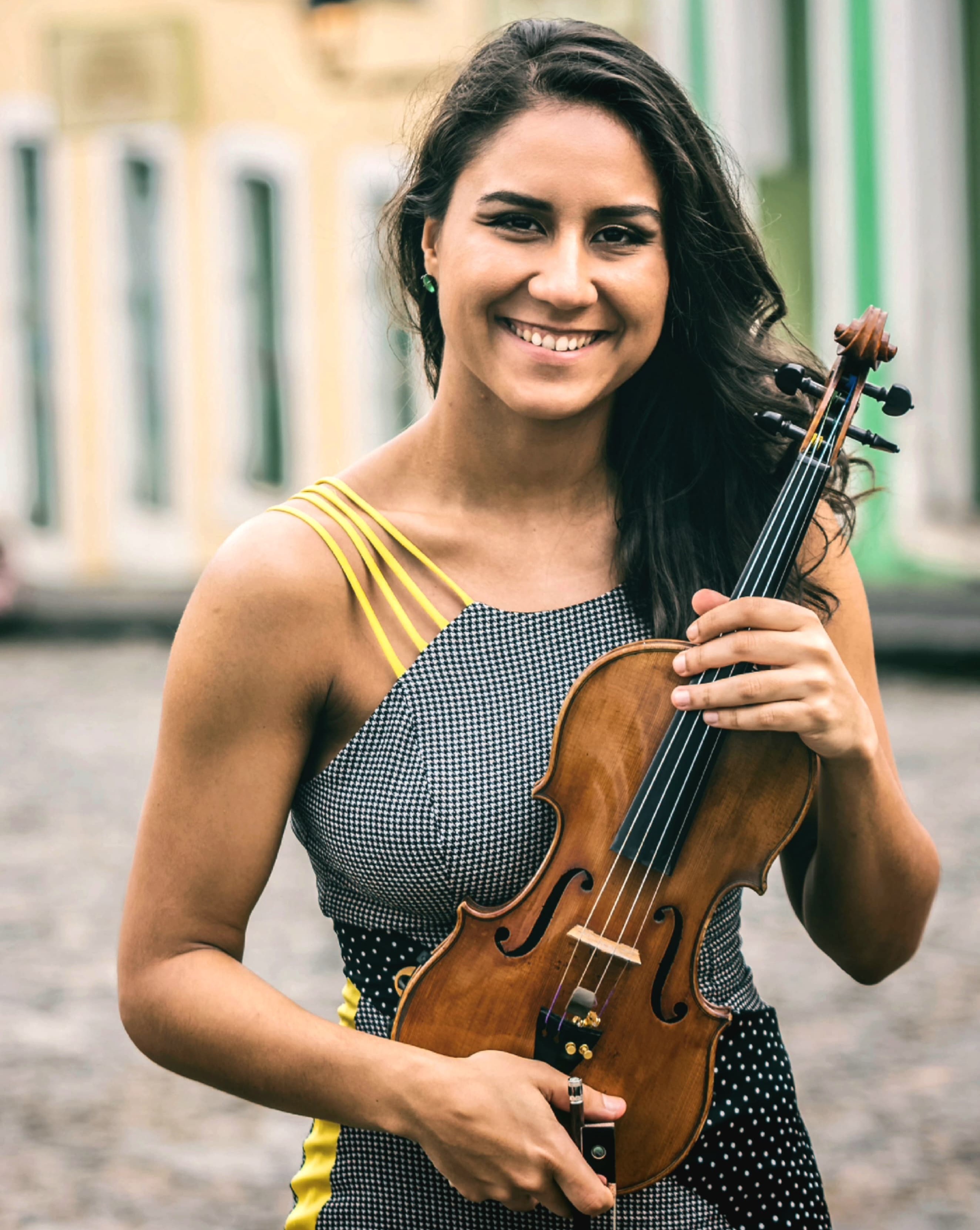 Foto da violinista Priscilla Rato em pé, posando com o violino.