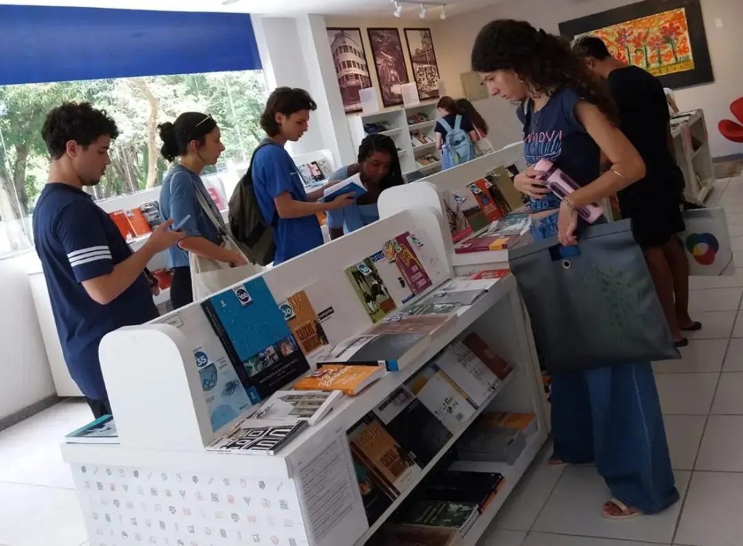 Estudantes olhando uma bancada com livros na Livraria da Ufes