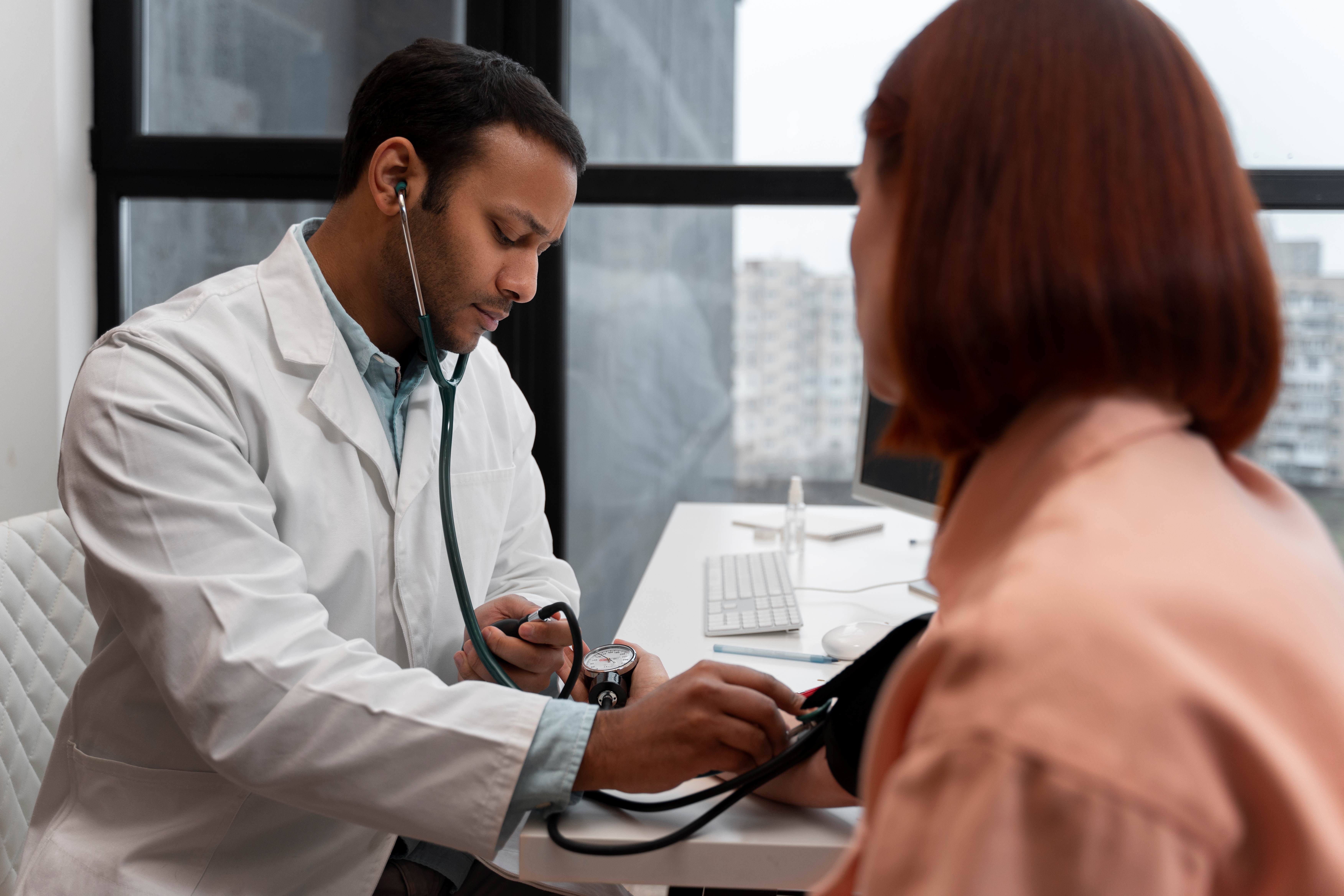 Imagem de um médico medindo a pressão de uma paciente