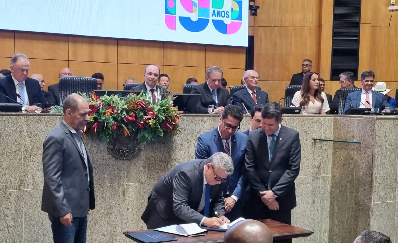 Foto do reitor da Ufes assinando o protocolo de intenções ao lado do presidente da Ales e das testemunhas