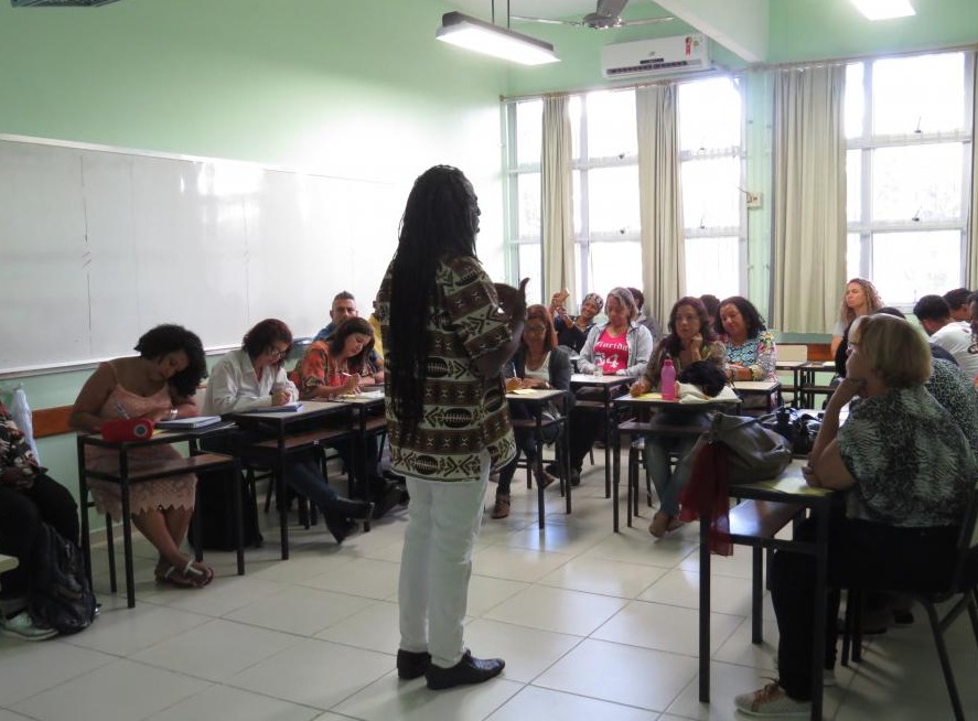 Foto de um professor negro diante de uma sala de aula