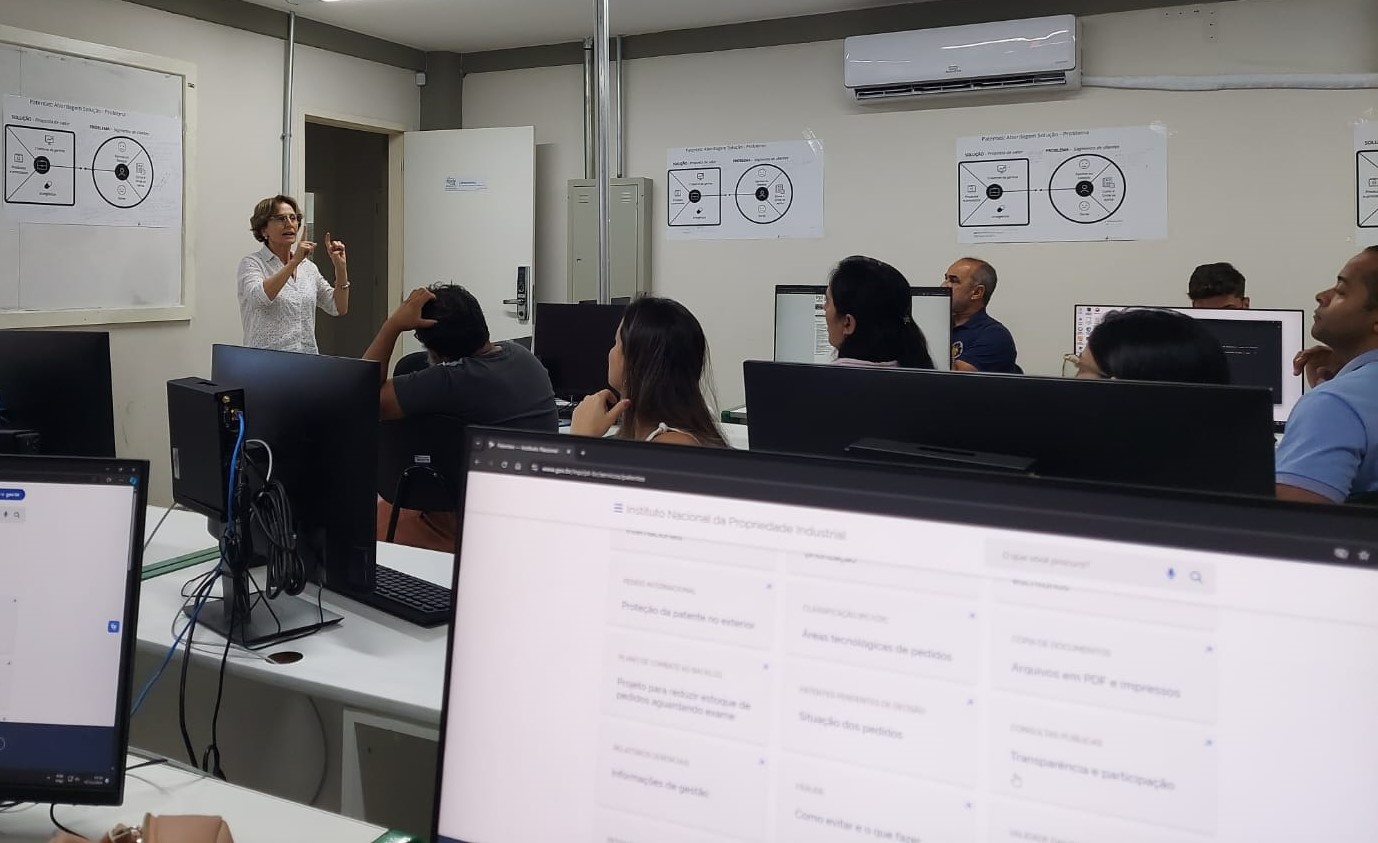 Foto de uma aula do workshop, com a professora à frente da sala