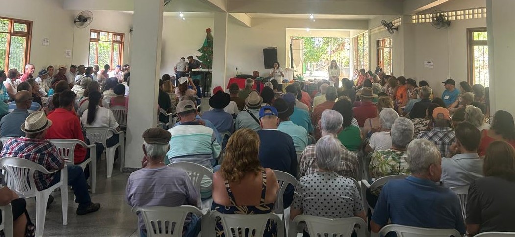 Foto do salão lotado do Centro de Convivência do Idoso, com as pessoas sentadas assistindo a uma palestra
