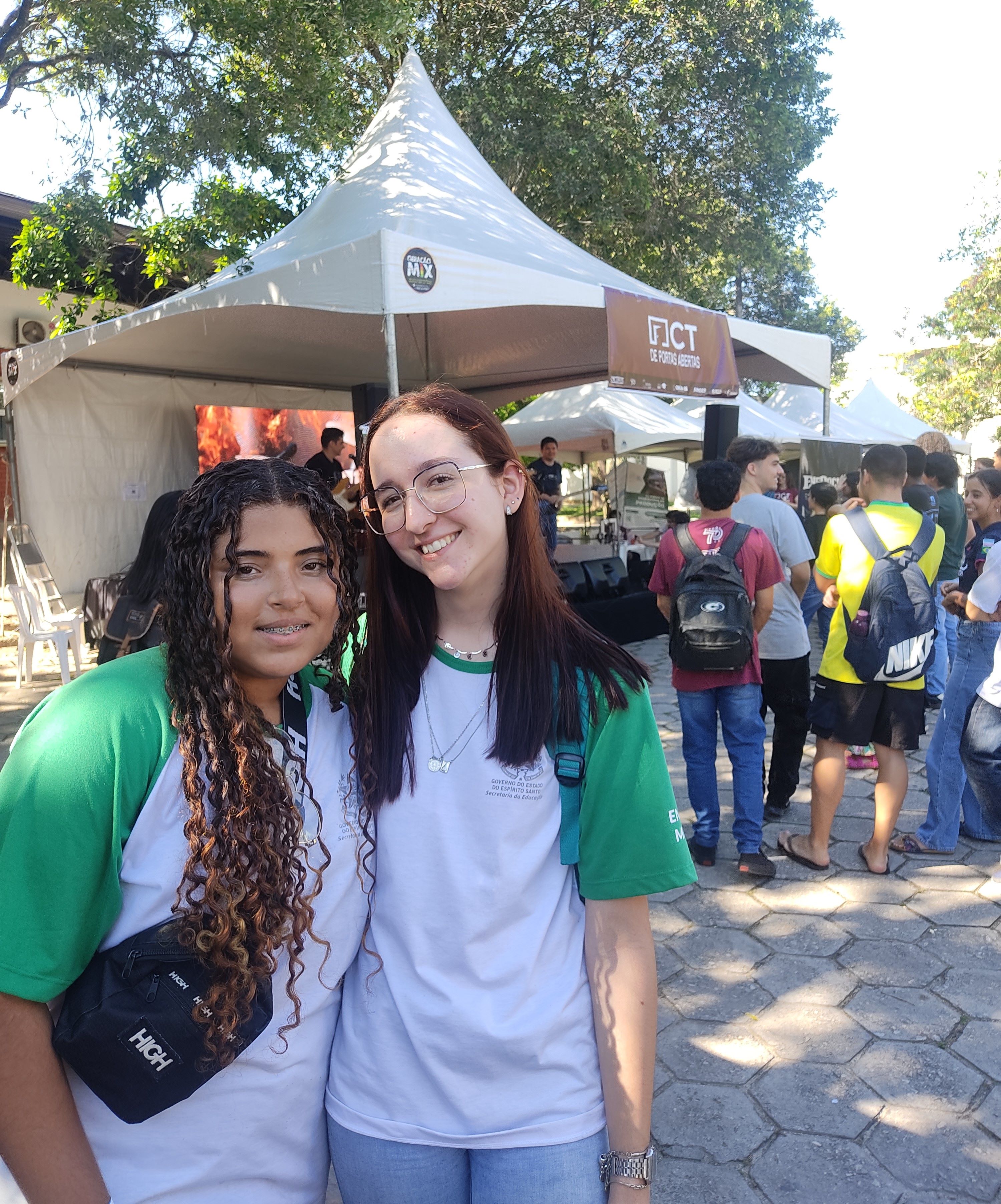 Foto das alunas Thayná Paulo e Thaís Barth, posando em frente a uma tenda