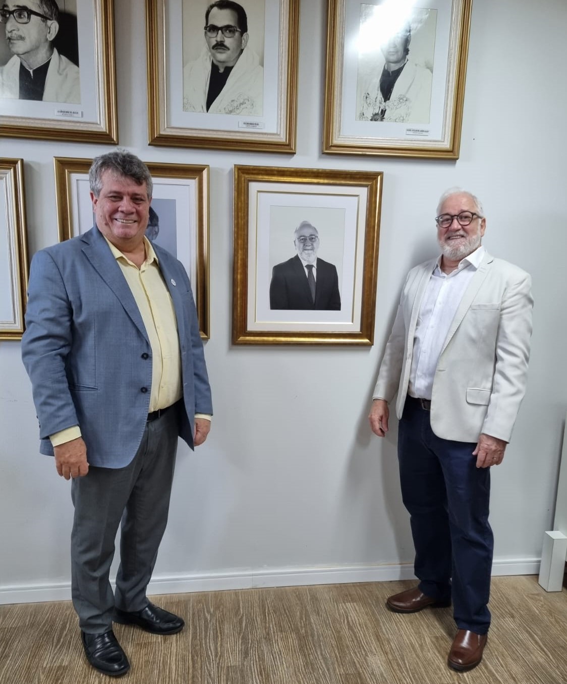 Foto: o reitor Eustáquio de Castro e o ex-reitor Paulo Vargas posam ao lado do quadro com a foto de Vargas na galeria de ex-reitores da Ufes