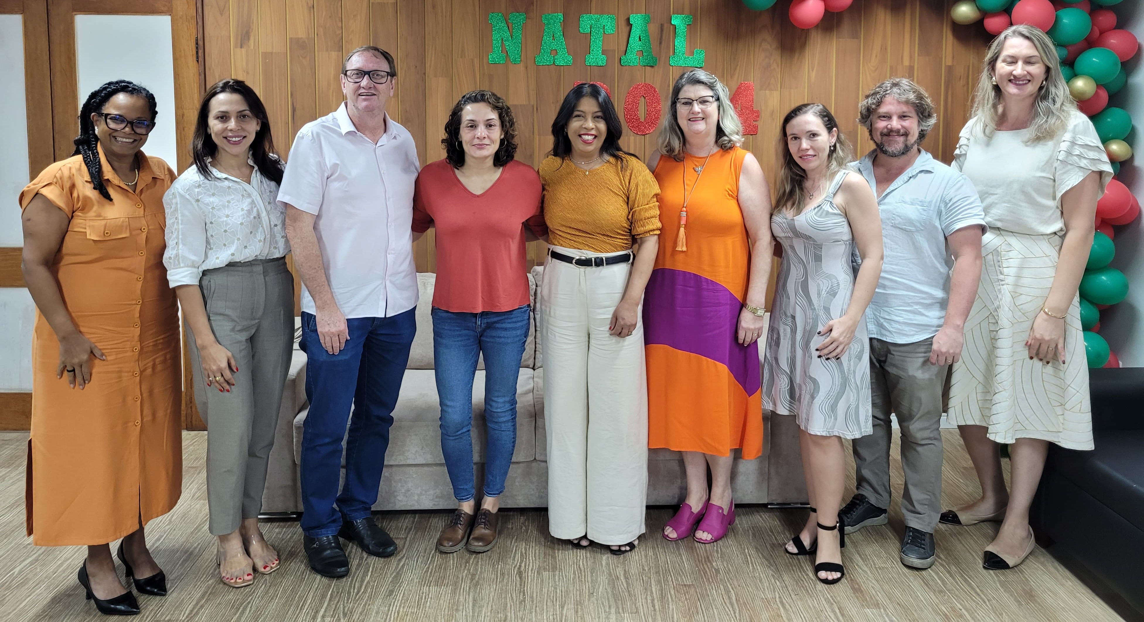 Foto de todos os participantes em pé, na sala de reuniões