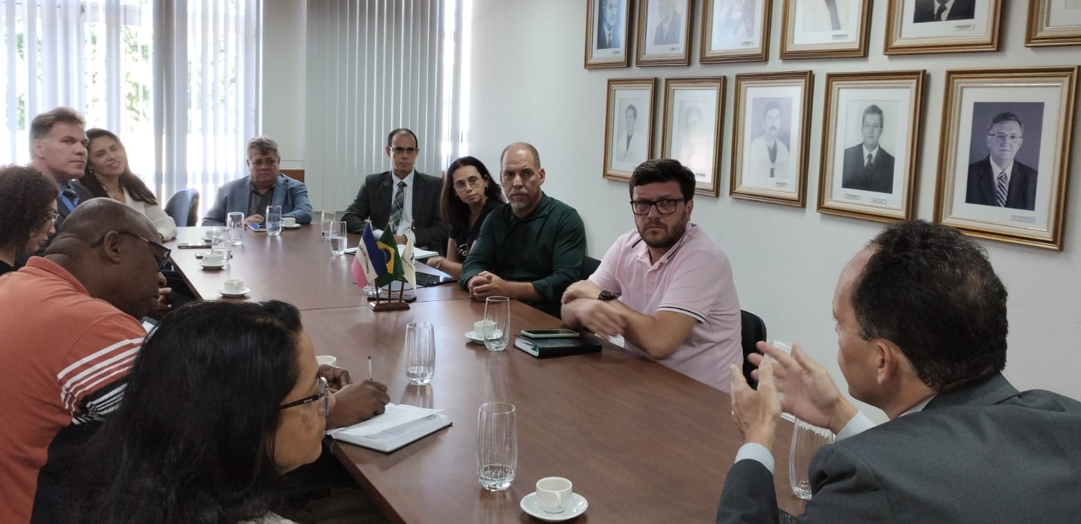 Foto dos participantes da reunião conversando em torno da mesa