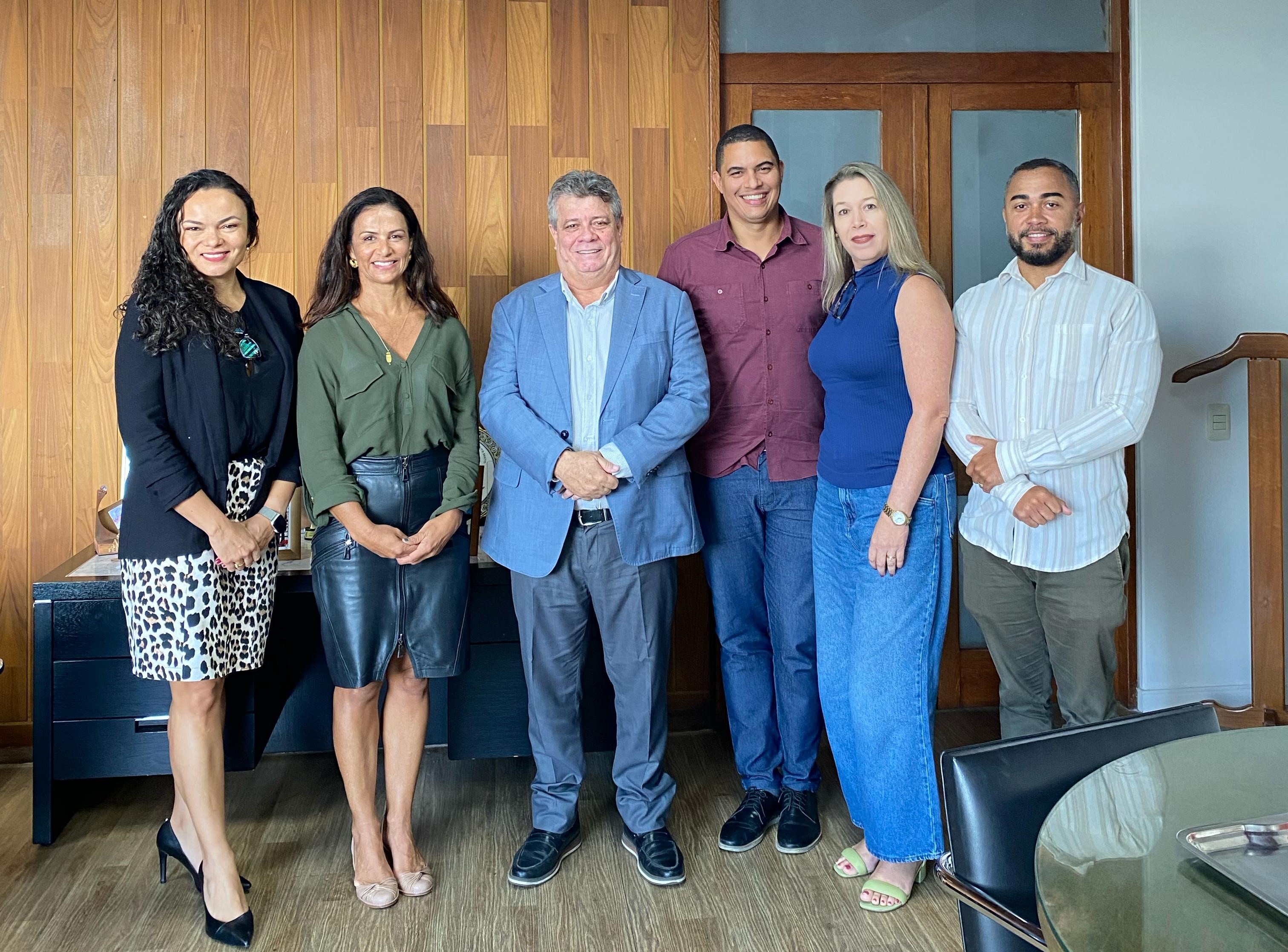 Foto dos participantes da reunião em pé, no gabinete do reitor