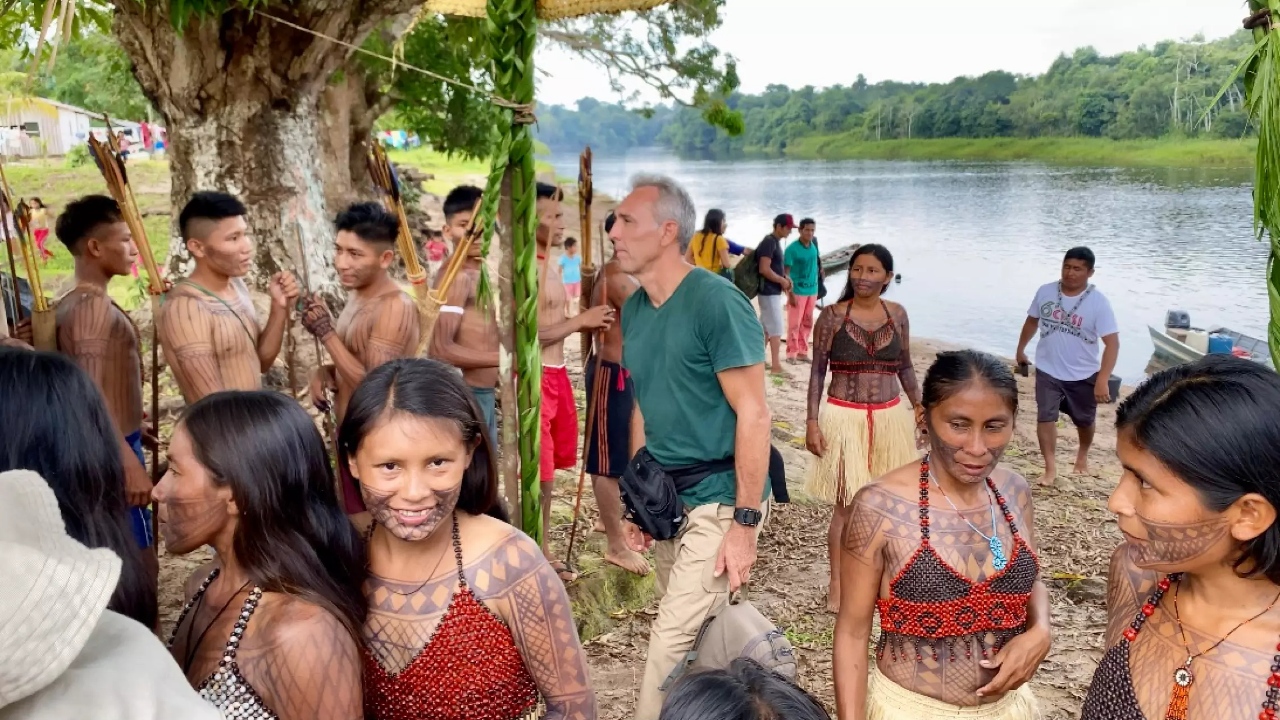 Cena do documentário na qual aparece vários indígenas à beira de um rio