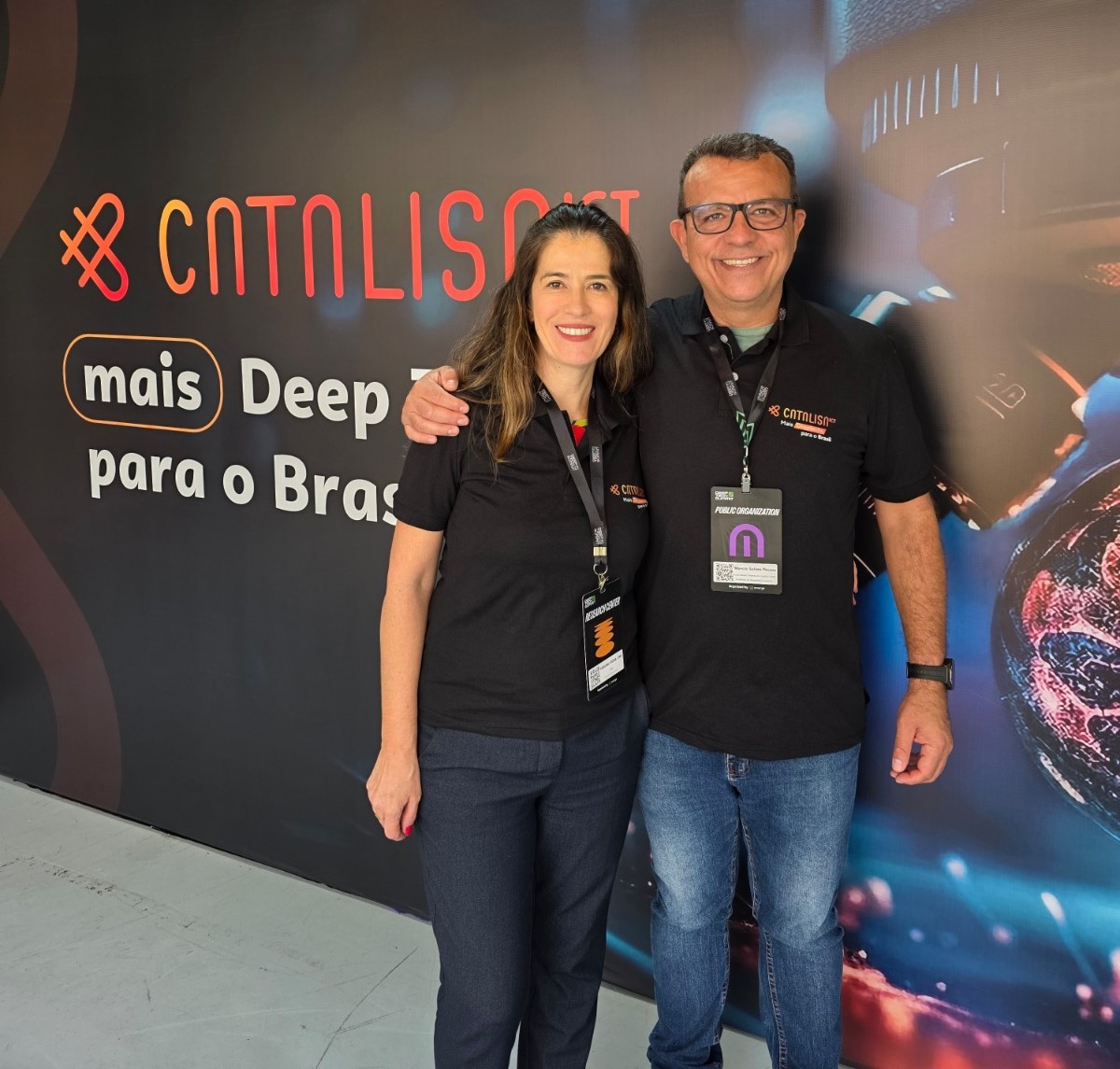 Foto dos professores em frente a um painel com o nome do programa