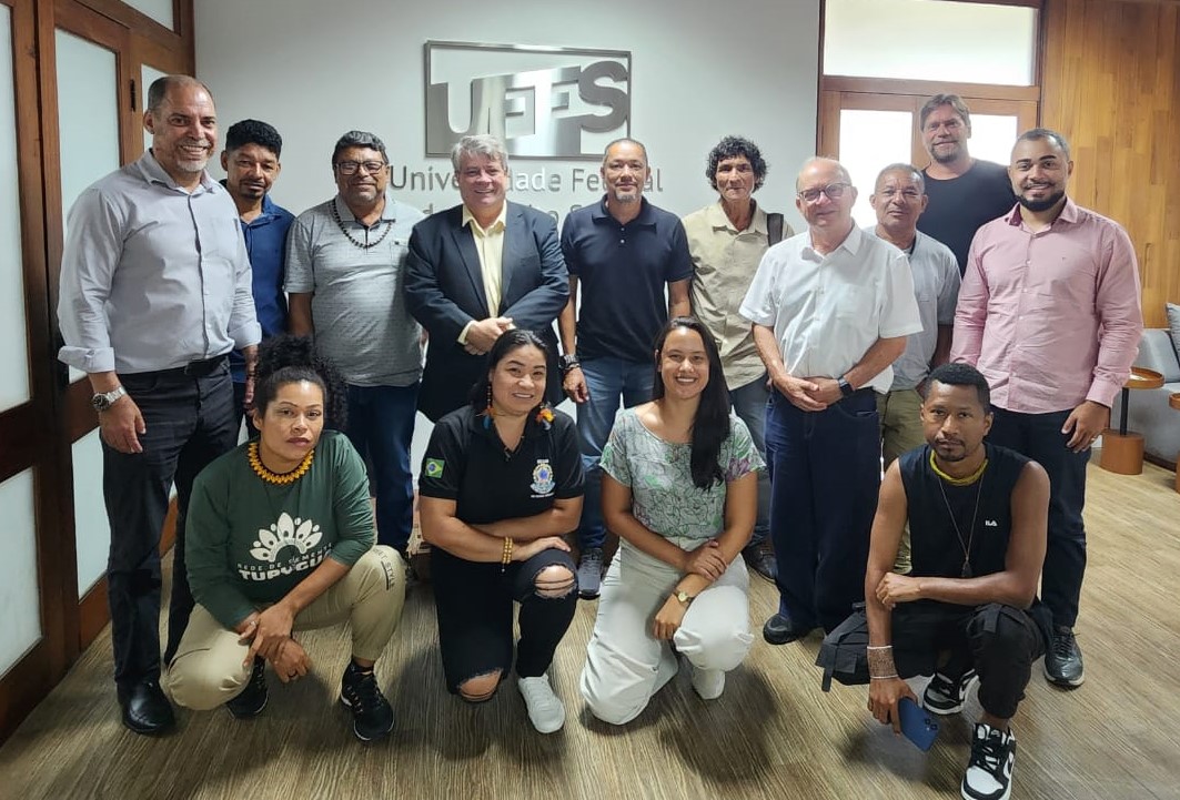 Foto posada dos participantes da reunião. Ao fundo, na parede, a logo da Ufes