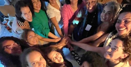 Grupo de mulheres unindo as mãos e olhando para cima