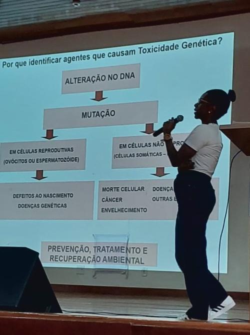 Foto da professora Tatiana Souza fazendo uma apresentação em um telão