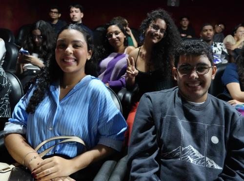 Estudantes na plateia sorrindo para a foto