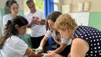 Foto de integrantes do Cepas coletando sangue de uma moça atendida pelo projeto