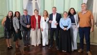 Foto das autoridades presentes com o governador segurando o termo de cooperação