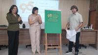 Foto da vice-reitora e dos diretores do Centro apresentando a placa comemorativa dos 95 anos do curso