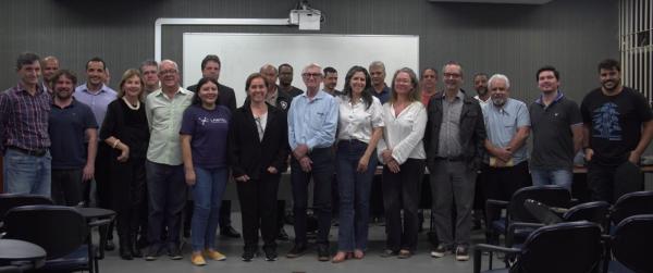 Foto de vários pesquisadores em pé, em um auditório, na apresentação do projeto de INCT