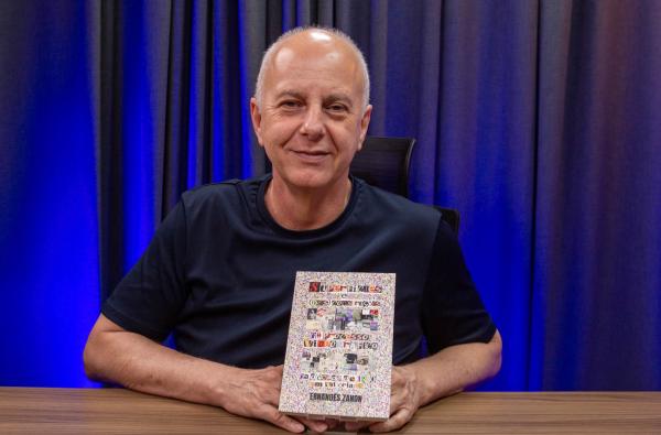 Foto do autor segurando o livro