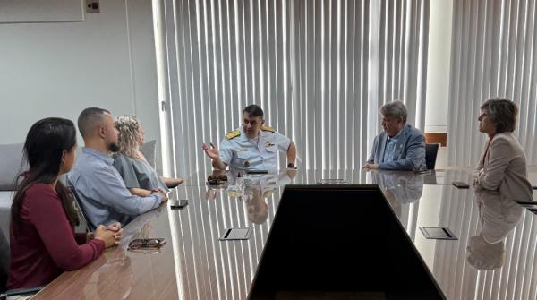 Foto da reunião, com os participantes conversando sentados à mesa