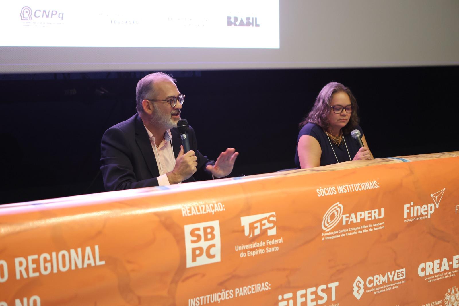 Foto do professor Balbinotto e de Francilene Garcia na mesa principal do evento