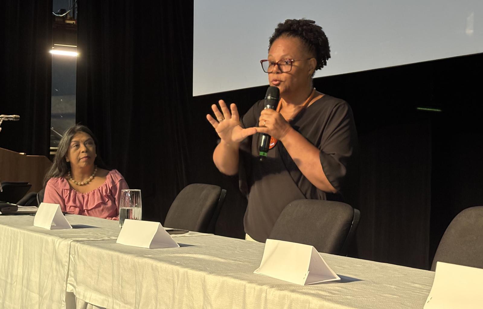 Foto de Joana Guimarães falando com a vice-reitora da Ufes prestando atenção