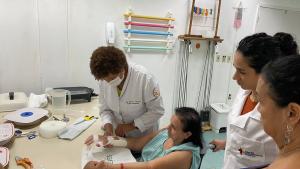 Foto da professora atendendo a uma senhora em um ambiente de reabilitação