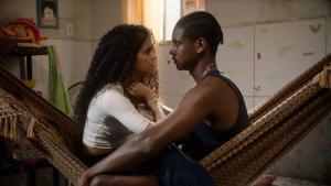 Cena de Ainda Não é Amanhã onde aparece um casal sentado em uma rede, um de frente para o outro