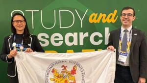 Os representantes da Ufes com a bandeira da Universidade à frente do estande