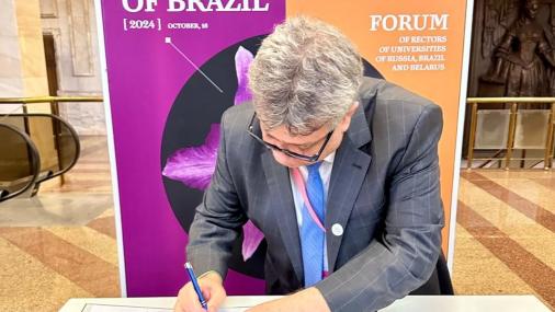 Foto do reitor Eustaquio de Castro assinando o documento de criação a Liga das Universidades do Brics