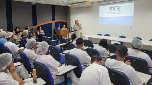 Foto da secretária Cinthya Oliveira falando para os trabalhadores no auditório 