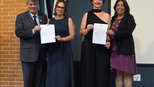 Foto das novas diretoras segurando o termo de posse ao lado do reitor e da vice-reitora